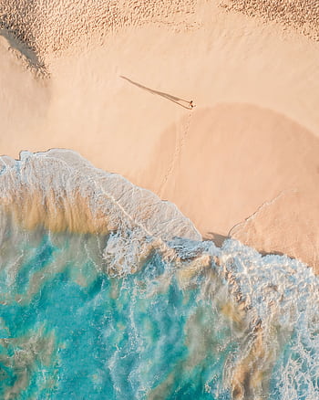 Stunning aerial shot capturing a serene sandy beach with turquoise waves, perfect for travel themes. HD phone wallpaper