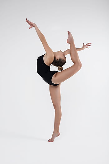 A skilled ballet dancer demonstrating flexibility and strength in a studio setting. HD phone wallpaper