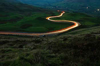 Majestic night view of light trails on a winding road in the English countryside. HD wallpaper