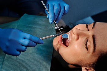 Close-up of a dentist examining a patient's teeth using dental tools. HD wallpaper