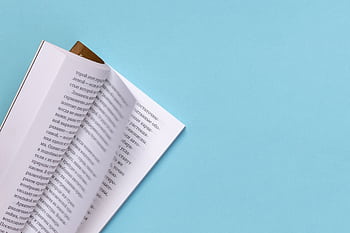 Open book with Russian text on a light blue background, minimalist composition. HD wallpaper