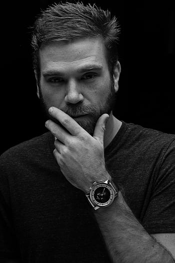 Black and white portrait of a thoughtful man wearing a wristwatch, looking pensive. HD phone wallpaper