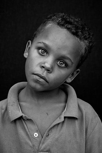 Black and white portrait of a young boy with a thoughtful expression. Captured in studio. HD phone wallpaper