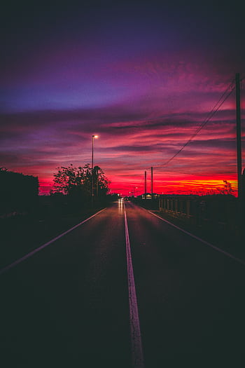 A captivating night view of a road under a dramatic twilight sky in Villafranca di Verona, Italy. HD phone wallpaper