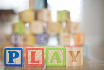 Close-up of colorful wooden blocks spelling 'PLAY', perfect for educational themes. HD wallpaper