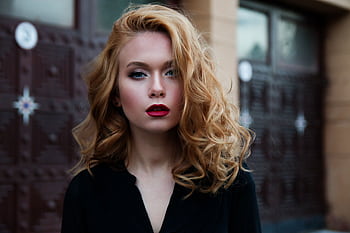 Elegant portrait of a woman in a black top with striking red lips and flowing blond hair. HD wallpaper