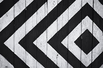 Black and white geometric pattern on wooden planks, ideal for modern design backgrounds. HD wallpaper