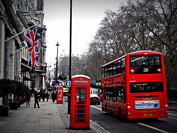 Classic London scene featuring a red double-decker bus and iconic booth on a busy city street. HD wallpaper