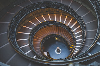 Intricate spiral staircase design in Vatican City offering a stunning architectural perspective. HD wallpaper