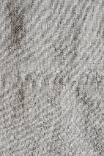 A textured and vintage linen fabric surface with natural wrinkles and neutral tones. HD phone wallpaper