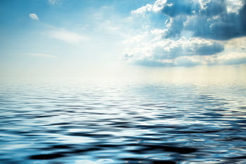 Peaceful ocean view with gentle waves under a partly cloudy sky. Perfect for calming backgrounds. HD wallpaper