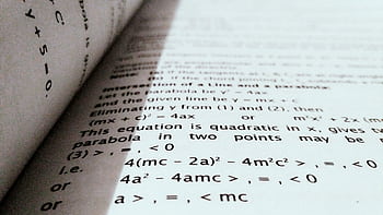 A close-up shot of mathematical equations on a book page, perfect for education and learning concepts. HD wallpaper