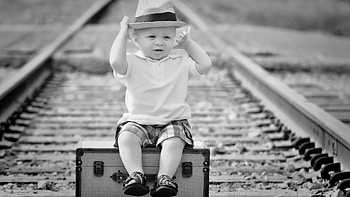 Black And White Of Cute Baby Boy Sitting On Travel Box In Railway Track Blur Background Cute HD wallpaper