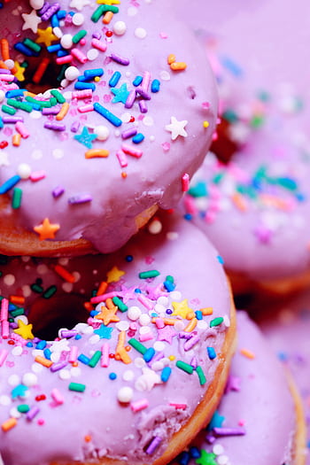 A close-up of vibrant donuts with purple icing and colorful sprinkles. HD phone wallpaper