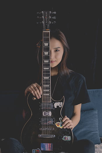 Asian woman sitting with an electric guitar, half-covered face, in an indoor setting. HD phone wallpaper