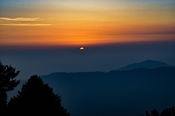 Sun setting behind the mountains HD wallpaper