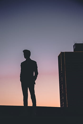 Silhouette of a man standing against a colorful Fort Worth sunset skyline, capturing urban tranquility. HD phone wallpaper