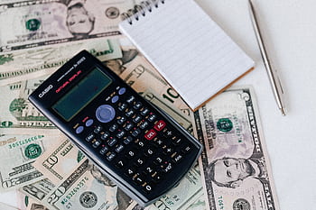Calculator, cash, and notebook on table for financial planning. HD wallpaper