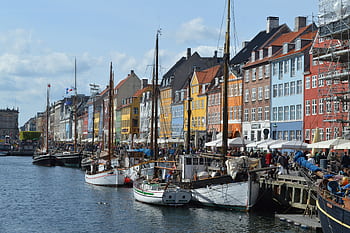 Vibrant waterfront scene of Nyhavn harbor with historic buildings and boats in Copenhagen. HD wallpaper
