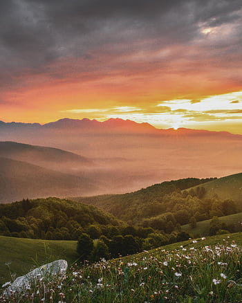 A serene mountain landscape at sunrise with misty valleys, lush forests, and vibrant skies. HD phone wallpaper