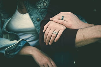 Close-up of a romantic couple's hands showing affection, with rings symbolizing love. HD wallpaper