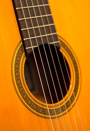 Detailed view of a classic acoustic guitar with intricate design. HD phone wallpaper