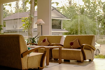 Elegant lobby with comfortable sofas, large windows, and natural light enhancing the indoor ambiance. HD wallpaper