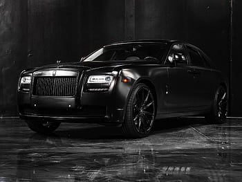 Catch the allure of a black luxury car in a sophisticated showroom, exuding elegance and power. HD wallpaper
