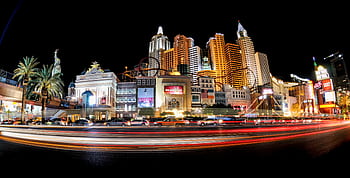 Illuminated cityscape of the Las Vegas Strip featuring iconic architecture and dazzling lights at night. HD wallpaper