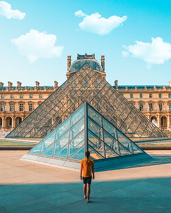 A person in front of the iconic glass pyramid at the Louvre Museum, Paris. HD phone wallpaper