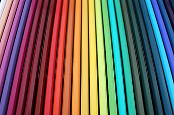 A vibrant and colorful arrangement of colored pencils forming a rainbow spectrum pattern. HD wallpaper