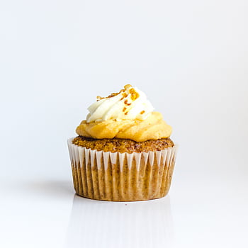 A delectable cupcake with creamy frosting on a white background, perfect for food graphy. HD phone wallpaper