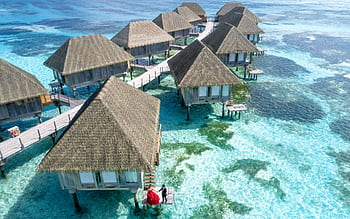 Stunning aerial view of overwater bungalows in Fuvahmulah, Maldives, with crystal clear waters. HD wallpaper