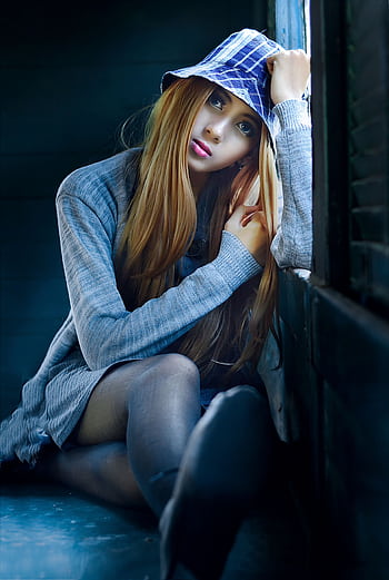 Captivating portrait of a woman with a blue hat, gazing by a window. HD phone wallpaper