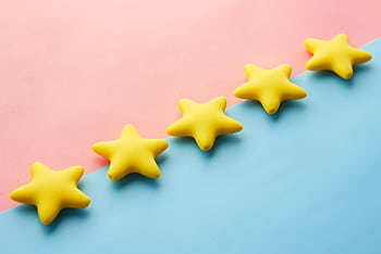 Yellow stars on pink and blue pastel background for rating or review concept. HD wallpaper