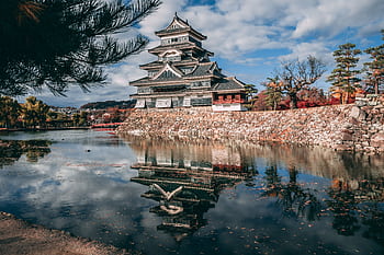 Reflection of Matsumoto Castle in Japan during autumn, surrounded by a serene lake. HD wallpaper
