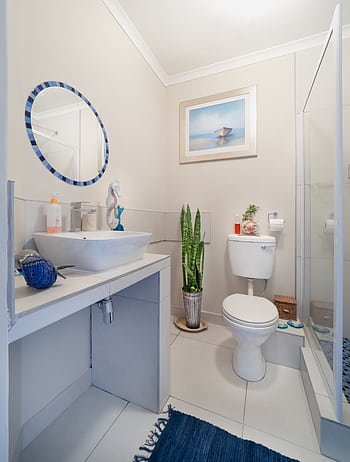 A clean, modern bathroom with white fixtures and minimalist decor, featuring a sink and toilet. HD phone wallpaper