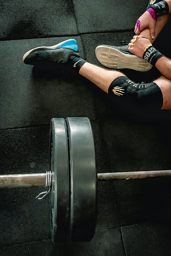 Close-up of an athlete in gym with weights focusing on fitness and strength. HD phone wallpaper