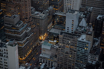 A dramatic aerial view of illuminated skyscrapers in Manhattan, New York City, showcasing urban architecture and city life at night. HD wallpaper