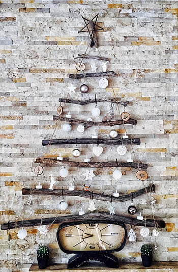 A unique DIY Christmas tree on a rustic brick wall, featuring natural materials and simple decorations. HD phone wallpaper