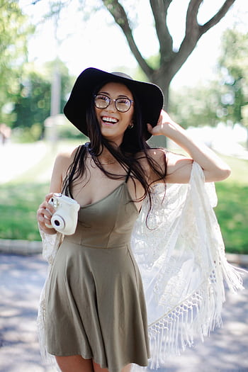 Cheerful woman in a boho dress with a camera enjoying a sunny day outdoors. HD phone wallpaper