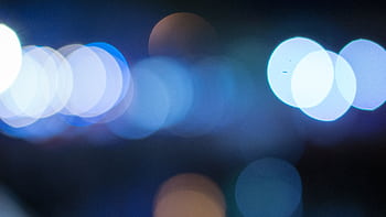 Blurred blue bokeh lights creating an abstract and dreamy visual effect. HD wallpaper