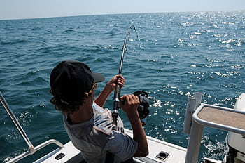 A young man actively fishing in the ocean near Broome, WA, enjoying a sunny day. HD wallpaper
