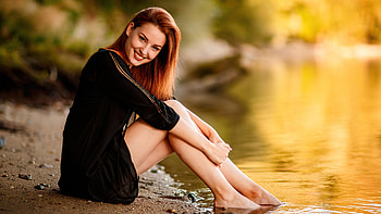 Redhead Smiley Girl Model Is Sitting On Sand In Blur Background Wearing Black Dress Girls HD wallpaper