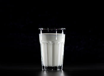A glass of fresh milk against a black background, emphasizing simplicity and nutrition. HD wallpaper