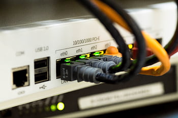Detailed close-up of ethernet cables and network connections on a router, showcasing modern technology. HD wallpaper
