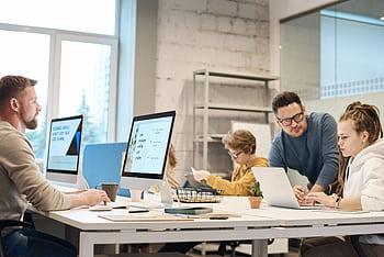 Team of professionals discussing project ideas in a modern office setting, fostering communication and teamwork. HD wallpaper