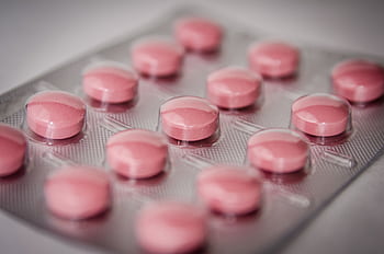 Pink tablets in a blister pack, emphasizing healthcare and medication concepts. HD wallpaper