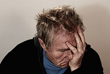 Portrait of an elderly man feeling stress and disappointment, holding his head in his hands. HD wallpaper