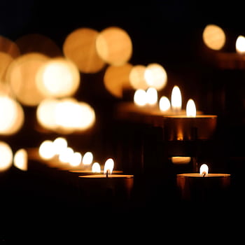 Soft focus on glowing candles with a charming bokeh effect, creating a warm ambiance. HD phone wallpaper